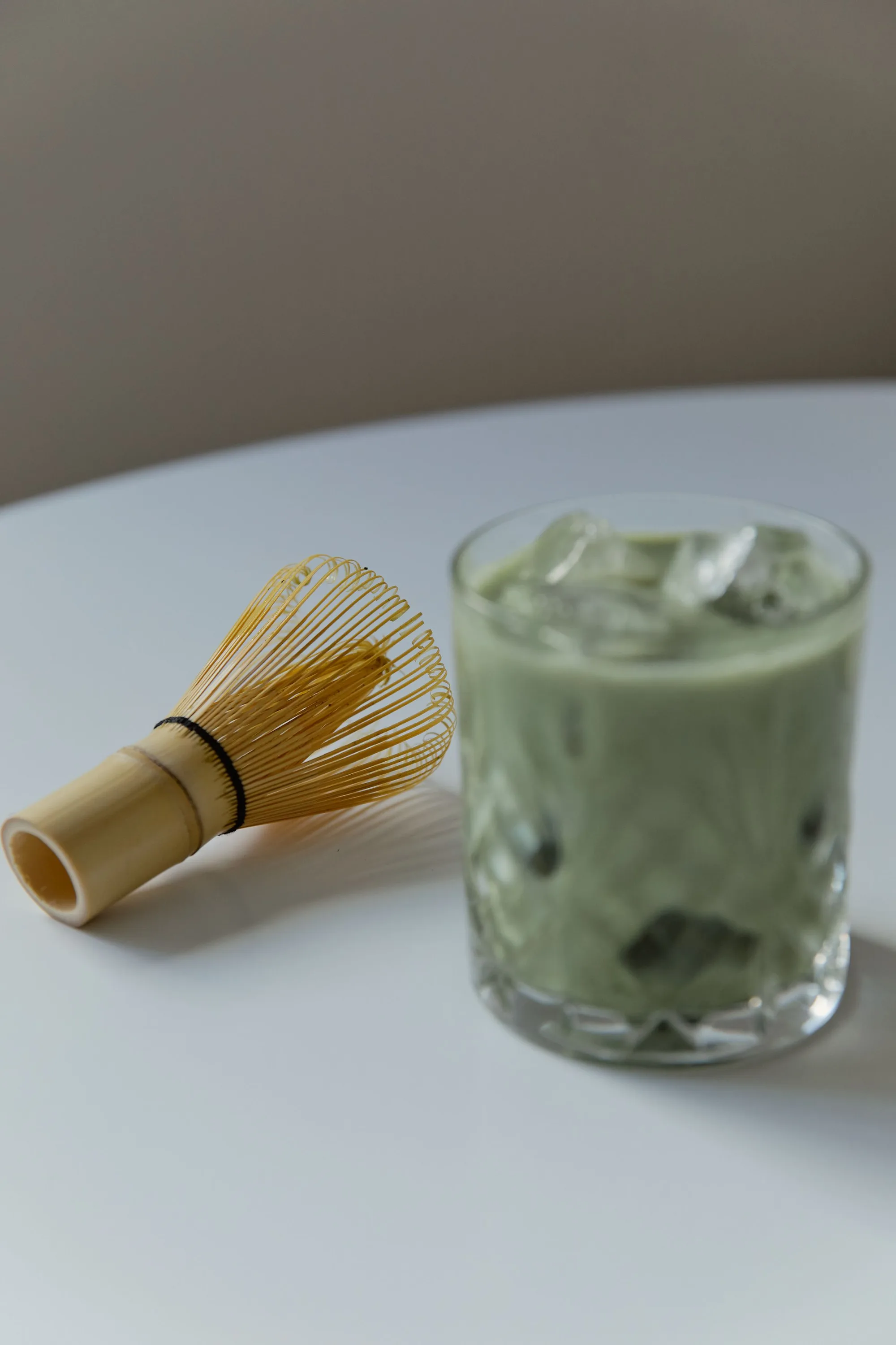 Iced matcha and a bamboo whisk