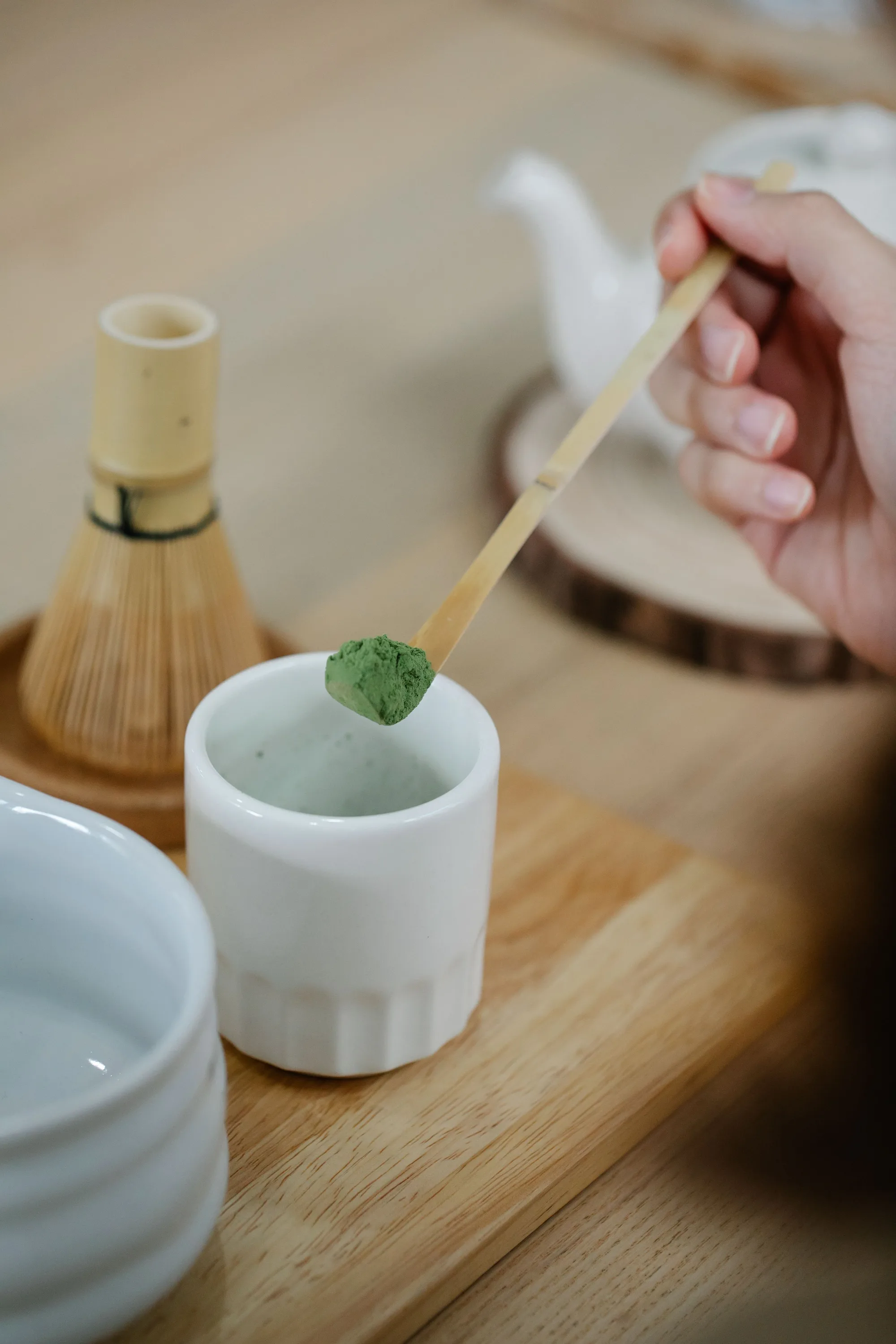 Matcha powder lifted on a bamboo scoop